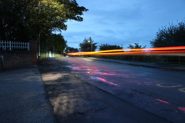 一辆汽车行驶在住宅道路上的长曝光照片图片下载