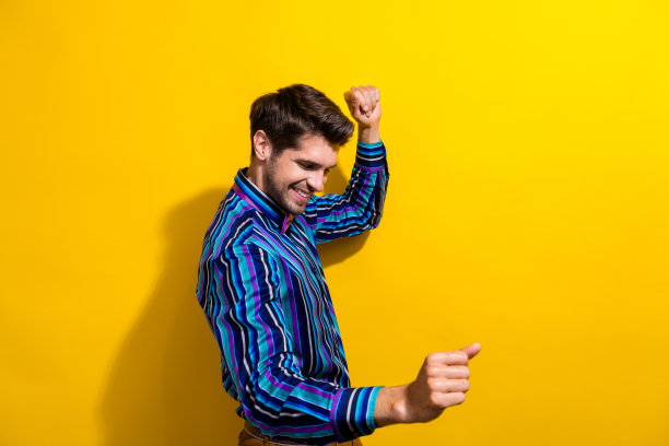 照片的好心情的男人鬃毛穿着条纹衬衫领结在公司活动中跳舞孤立的鲜艳的黄色背景图片下载
