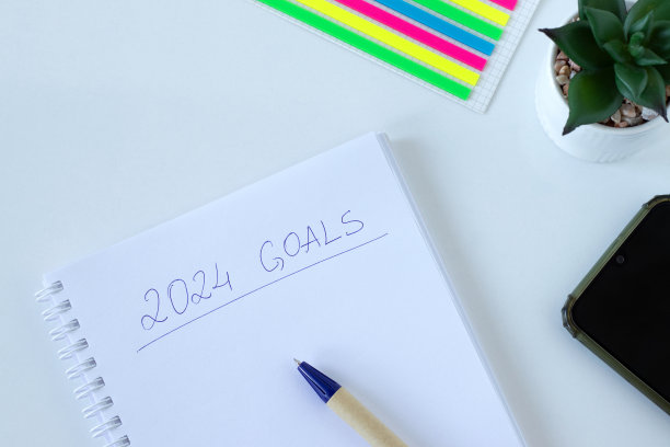 2024年的目标，用钢笔和智能手机在笔记本上手写的文字，白色背景，俯视图图片下载