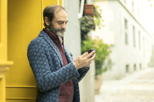 老人在街上使用手机。带复制空间的照片图片下载
