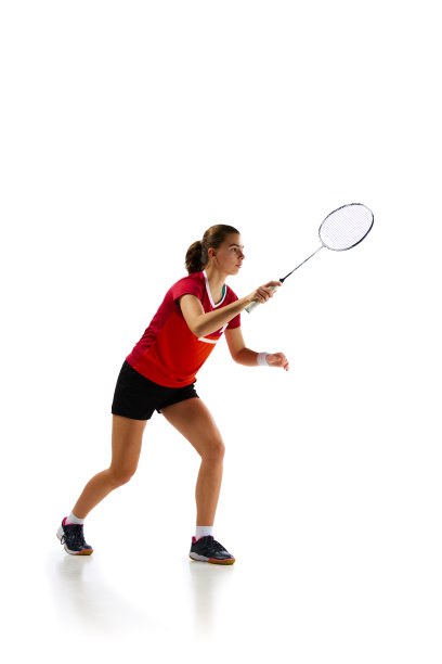 美丽和勇猛。年轻而有吸引力的羽毛球运动员在运动的肖像，在白色背景下勤奋地训练。图片下载