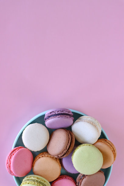 彩色马卡龙的图片，里面装满了奶油、草莓、香草、蓝莓、橘子、开心果、巧克力味的蛋白霜，粉红色的背景，高架的视图，复制空间图片下载