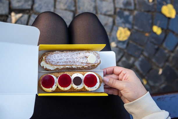 年轻女子正在吃法式甜糕点图片下载