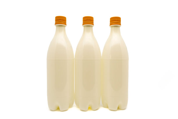 三个浅棕色瓶盖的塑料瓶，在白色背景上与复制空间隔离。饮料包装。图片下载