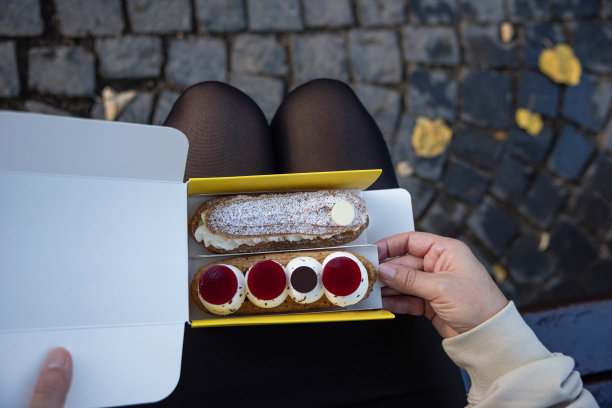 年轻女子正在吃法式甜糕点图片下载