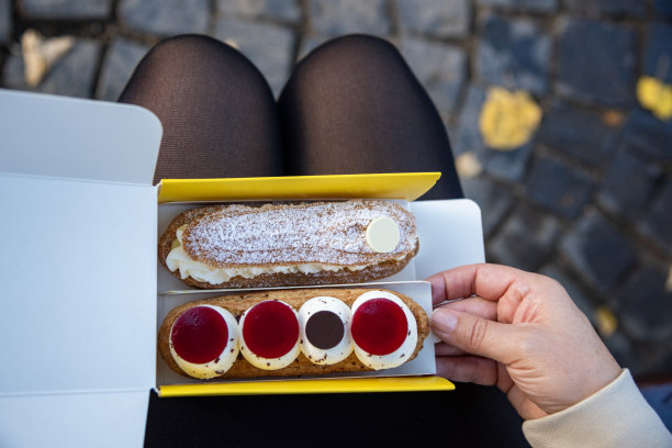 年轻女子正在吃法式甜糕点图片下载