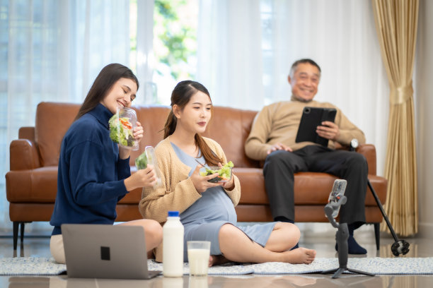 亚洲孕妇在家通过社交媒体吃蔬菜沙拉奶让其他妈妈看着图片下载