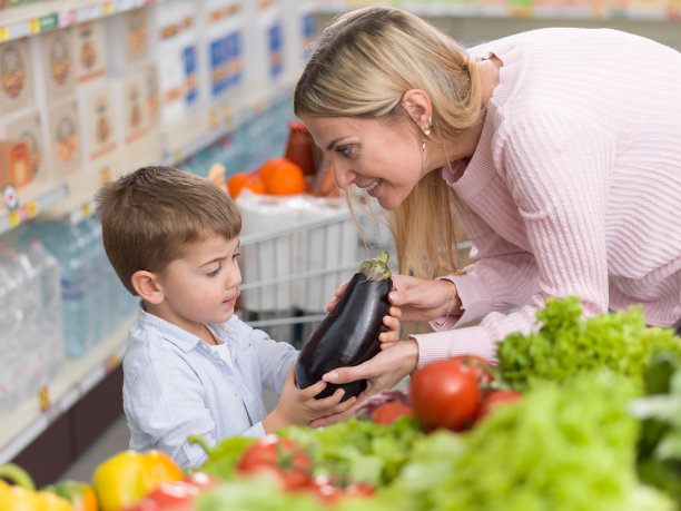 母亲在超市向儿子展示健康蔬菜图片下载