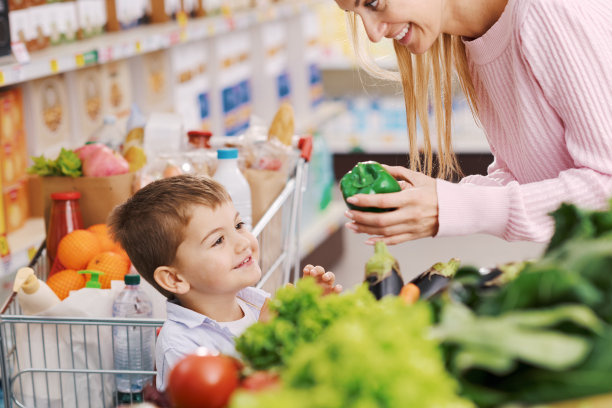 慈祥的母亲和孩子一起去杂货店买东西图片下载
