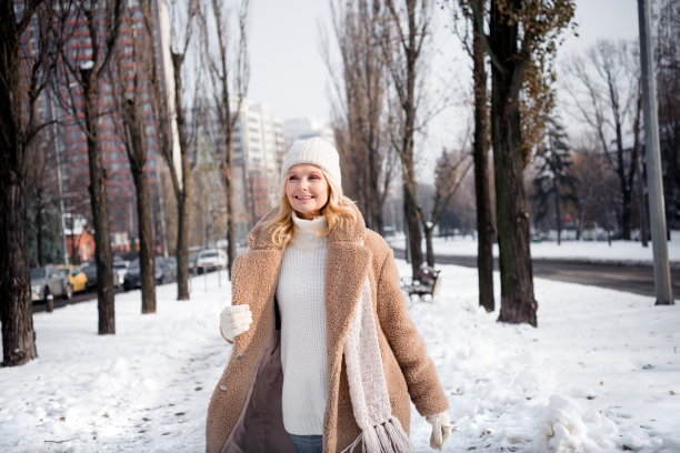 照片正面可爱的可爱的女人穿着温暖的外套在外面的雪公园消遣图片下载