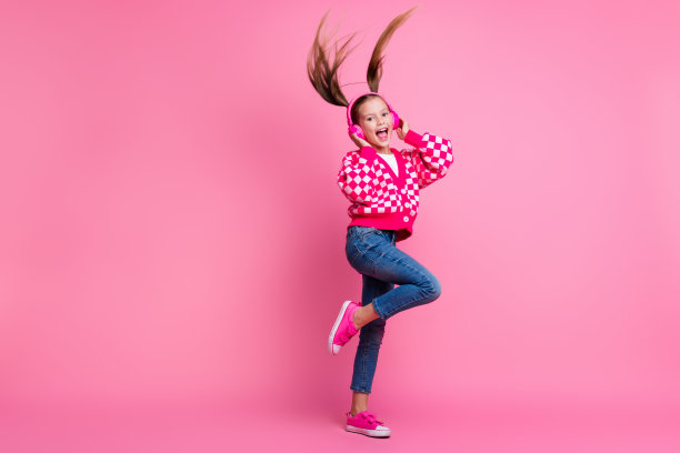 照片积极积极精力充沛的女孩时尚的衣服听舞蹈音乐播放列表有乐趣的空间孤立在粉红色的背景图片下载