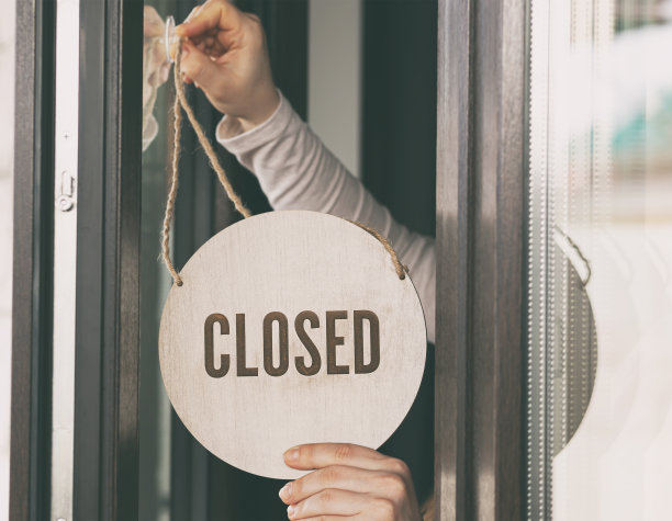 女子手里拿着写着“关门”的木牌图片下载