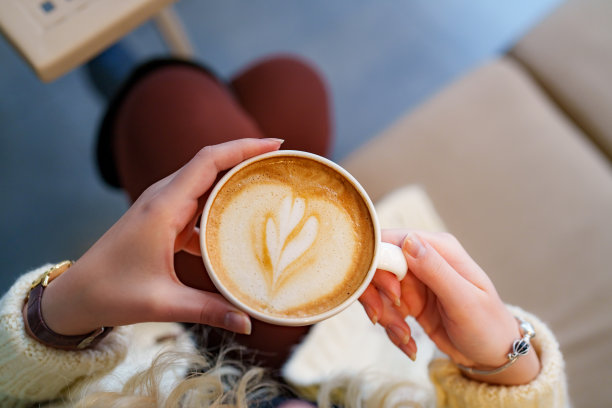 女人拿着一杯泡沫艺术正上方。图片下载
