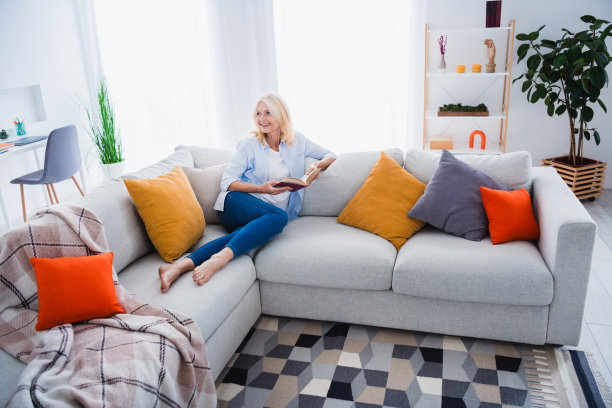 可爱的高级女士的照片肖像读书沙发出租公寓房子室内设计舒适的客厅现代家居装饰图片下载