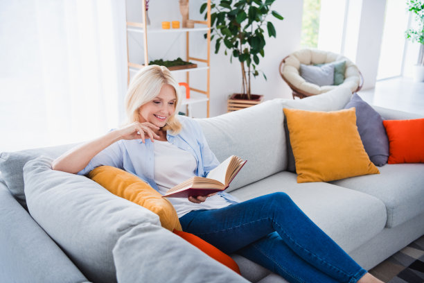 可爱的高级女士读书的照片肖像坐沙发书呆子读书的房子室内设计舒适的客厅现代家居装饰图片下载