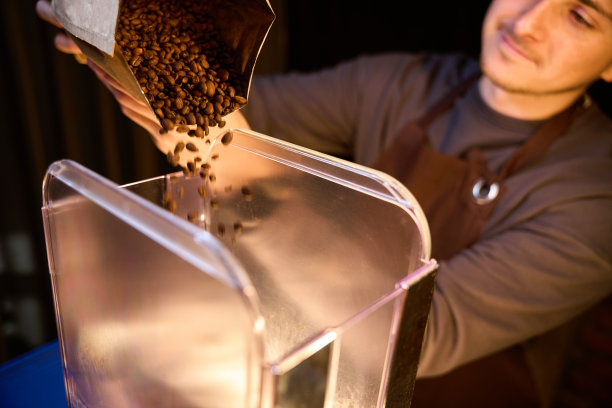 咖啡机将咖啡豆倒入研磨粉中，以冲泡现磨咖啡图片下载