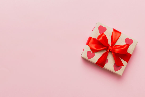 情人节装饰礼盒与红丝带蝴蝶结彩色背景的俯视图照片。假日礼盒与顶视图图片下载