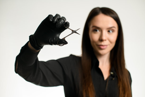 年轻迷人女性的肖像，美甲师或指甲护理美容师拿着修指甲剪刀图片下载