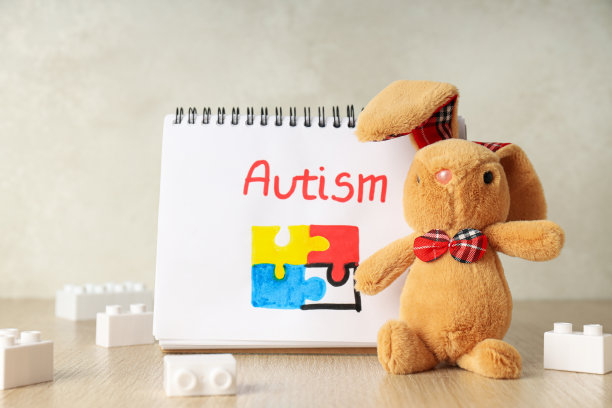 浅色背景上写着“自闭症”的笔记本。世界自闭症日概念图片下载