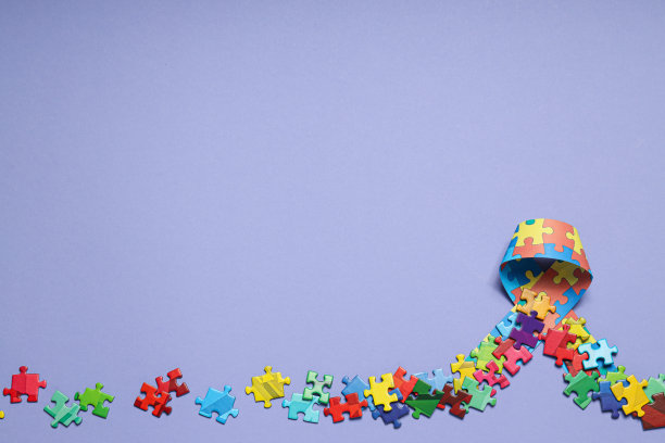 色带与多色拼图片在浅色背景，文字的地方。世界自闭症日概念图片下载