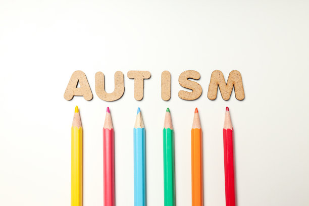 白色背景上有“自闭症”字样的彩色铅笔。世界自闭症日概念图片下载