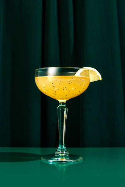 近距离的照片异国情调的酒精饮料在高脚杯与宽口装饰橙片坐在绿色的桌子上。图片下载