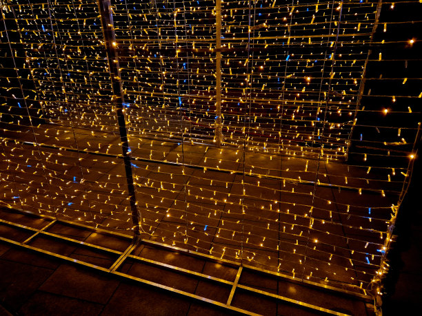 Led链以密密麻麻的间距缠绕在金属结构上。在夜间创造明亮的表面和装饰饰品。圣诞装饰，墙，帐篷，人物，准备。市场营销图片下载