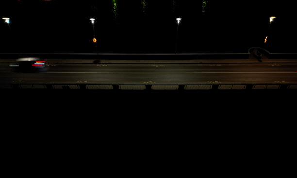 汽车经过的夜桥。灯光模糊地照亮了河上的轮廓。无人机的交通状况，警方监控，交通专家，追逐偷车贼图片下载