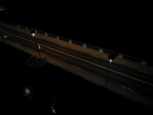 汽车经过的夜桥。灯光模糊地照亮了河上的轮廓。无人机的交通状况，警方监控，交通专家，追逐偷车贼图片下载