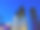 柏林蔚蓝的夜晚被摧毁的福音教堂钟楼和现代霓虹灯照亮的建筑物与路灯和光秃秃的树枝剪影图片下载