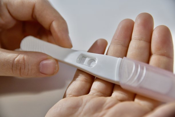 一个女孩手里拿着验孕棒，等待着她的反应图片下载