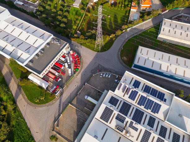 葡萄牙的物流中心鸟瞰图，顶部有太阳能电池板，附近有一个高压塔，以及相关的车队图片下载