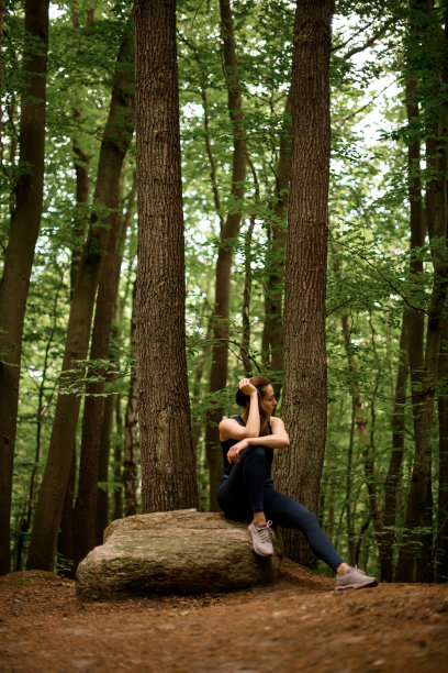 年轻的运动女性在锻炼、锻炼或训练后在大自然中休息的垂直照片图片下载