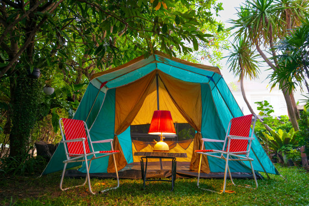 复古的小屋帐篷，古色古香的油灯放在木桌和复古的椅子上。在森林里图片下载