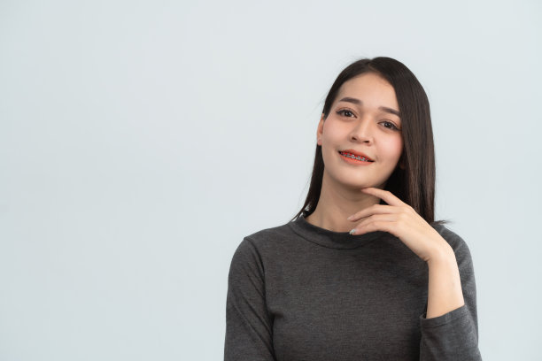 亚洲女性牙套。牙齿矫正器戴在女性洁白的牙齿上，使牙齿均匀。托架系统在微笑的嘴，近距离照片牙齿，微距拍摄，牙医的健康理念。图片下载