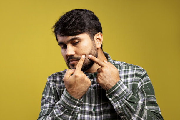 一个男人用手指捂着脸上的黑头图片下载