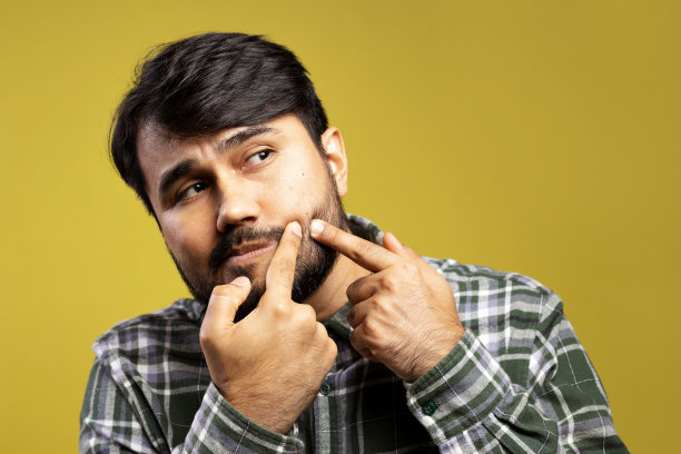 一个男人用手指捂着脸上的黑头图片下载