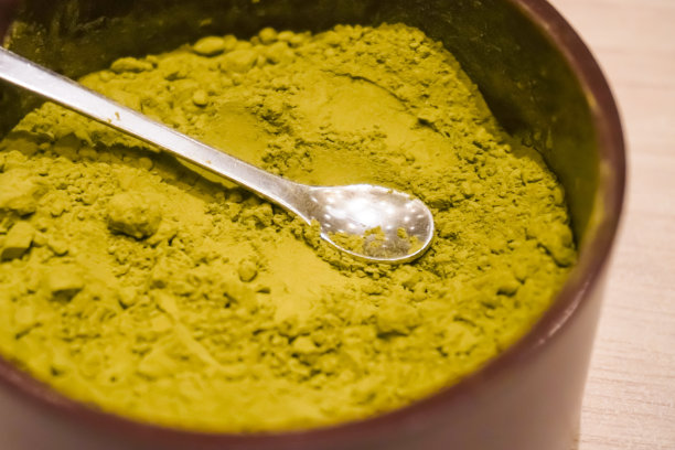 小银勺和日本绿茶粉在东方经典陶瓷碗。餐厅木桌上的日式ocha。草药饮料的概念，替代医学。特写照片图片下载