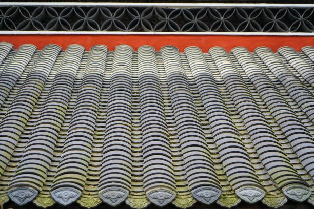 红色的屋顶，整齐排列的灰色瓦片。瓷砖上有一些青苔。图片下载