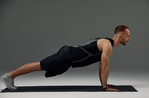 在室内地板上做平板支撑的帅哥图片下载