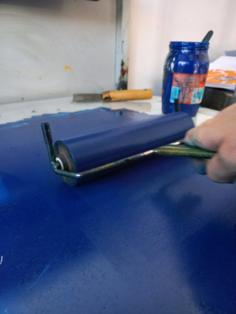 用滚筒给油布印版上漆图片下载