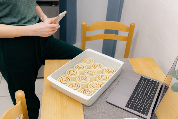 一个小女孩正在给桌上烤盘里的生肉桂拍照。图片下载