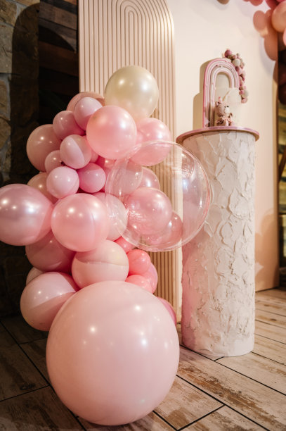 拱门上装饰着粉红色、棕色的气球。蛋糕上装饰着熊的身影、彩虹。时髦的女孩洗礼蛋糕。生日聚会上美味的招待会。照片墙装饰空间或文字的地方。图片下载