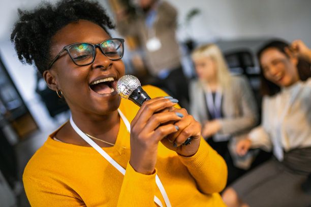 商务人士在团队建设研讨会上唱卡拉ok进行团队训练练习图片下载