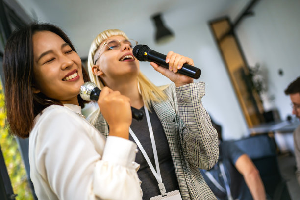 商务人士在团队建设研讨会上唱卡拉ok进行团队训练练习图片下载