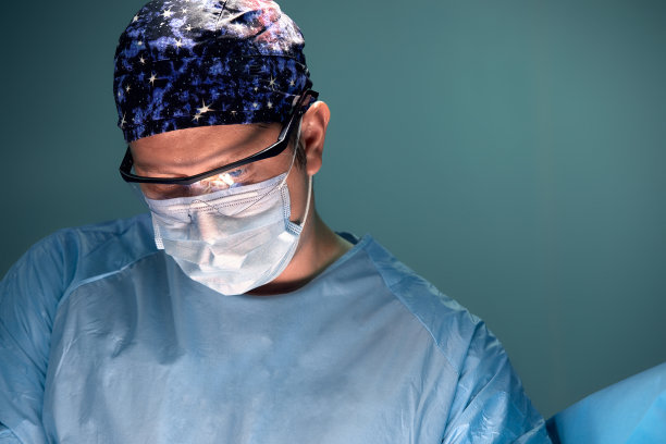 医生在昏暗的手术室里做手术，背景是灯图片下载