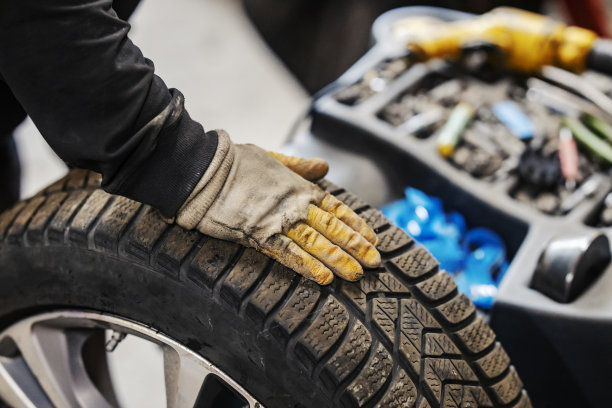 一名硫化工人在车间平衡汽车车轮的裁剪图片。图片下载