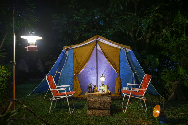 复古小屋帐篷，古色古香的油灯，复古的椅子，一组露营帐篷，在森林里的森林露营区，在木桌上有户外咖啡制作设施图片下载