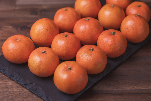 水果。照片中的橘子在黑色的石板上一字排开。图片下载