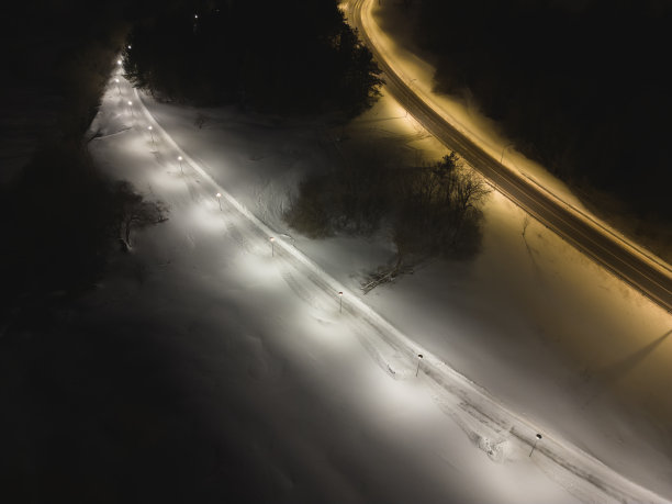 冬季无人机拍摄的夜间照片。步行路、路灯路和汽车路。Pirita。图片下载